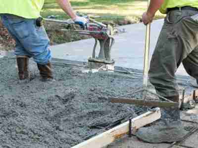 Two men working on a concrete slab.