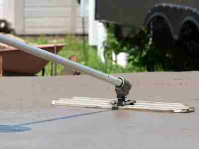 A person is using a metal tool to cut the roof of a house.