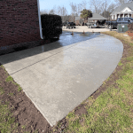 A driveway with concrete on the side of it