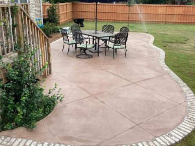 Stamped concrete patio with umbrella and table.