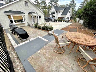 A patio with a table and chairs, grill and barbecue.