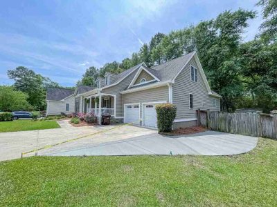 A large house with a driveway and lots of trees.